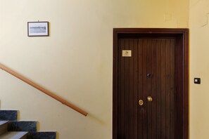 A wooden door with a brass handle and a small sign above it. - Alice’s House Apartment with Balcony, Wi-Fi, and Air Conditioning (Roma)