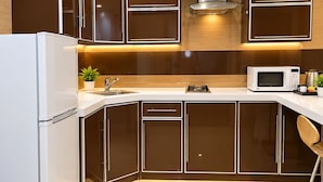 A modern kitchen with a white refrigerator, stainless steel sink, and a microwave. - Manazilna Serviced Apartments (Riyadh)