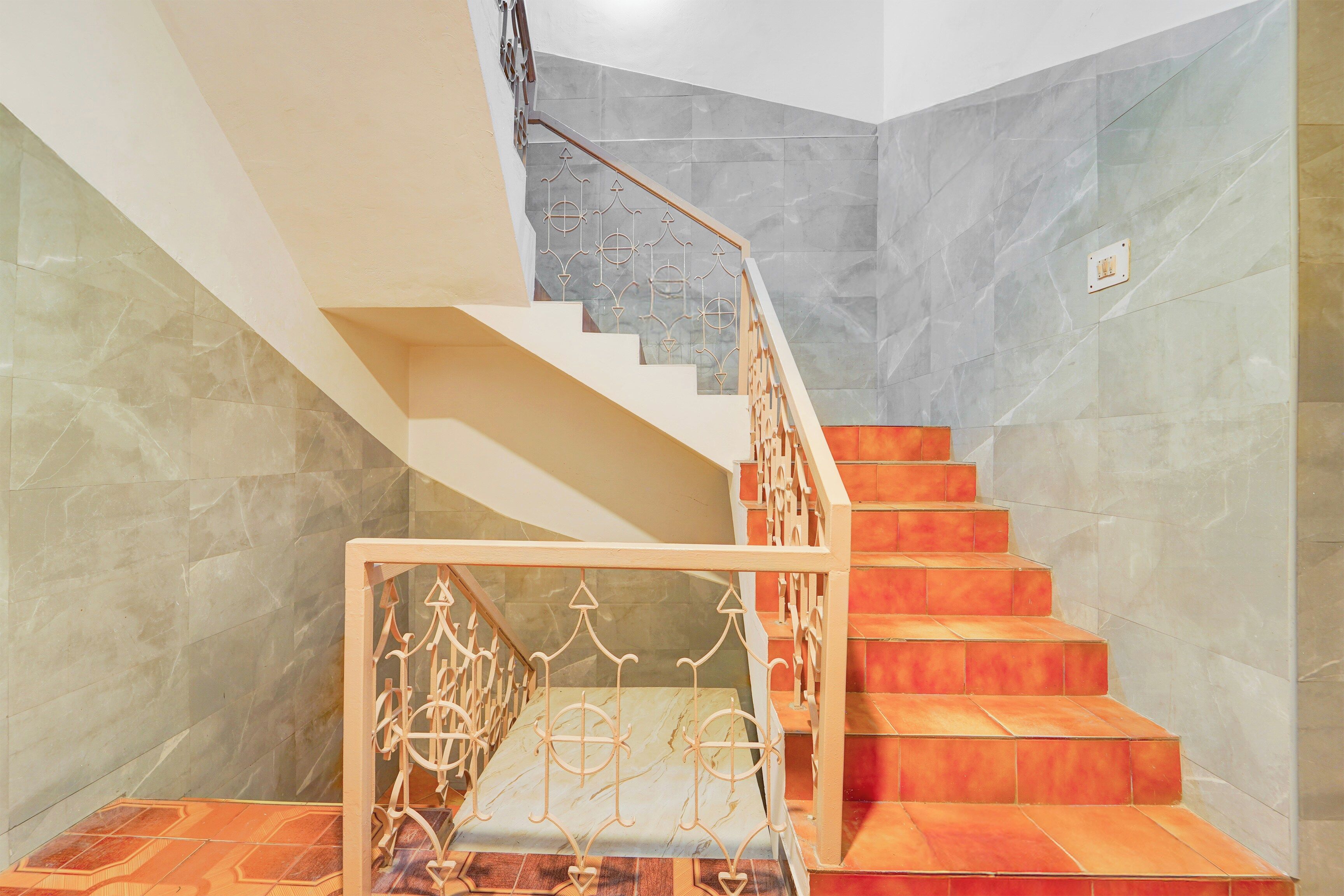 Una escalera con barandilla de metal y suelo estampado.