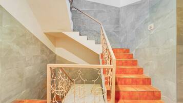 Una escalera con barandilla de metal y suelo estampado.