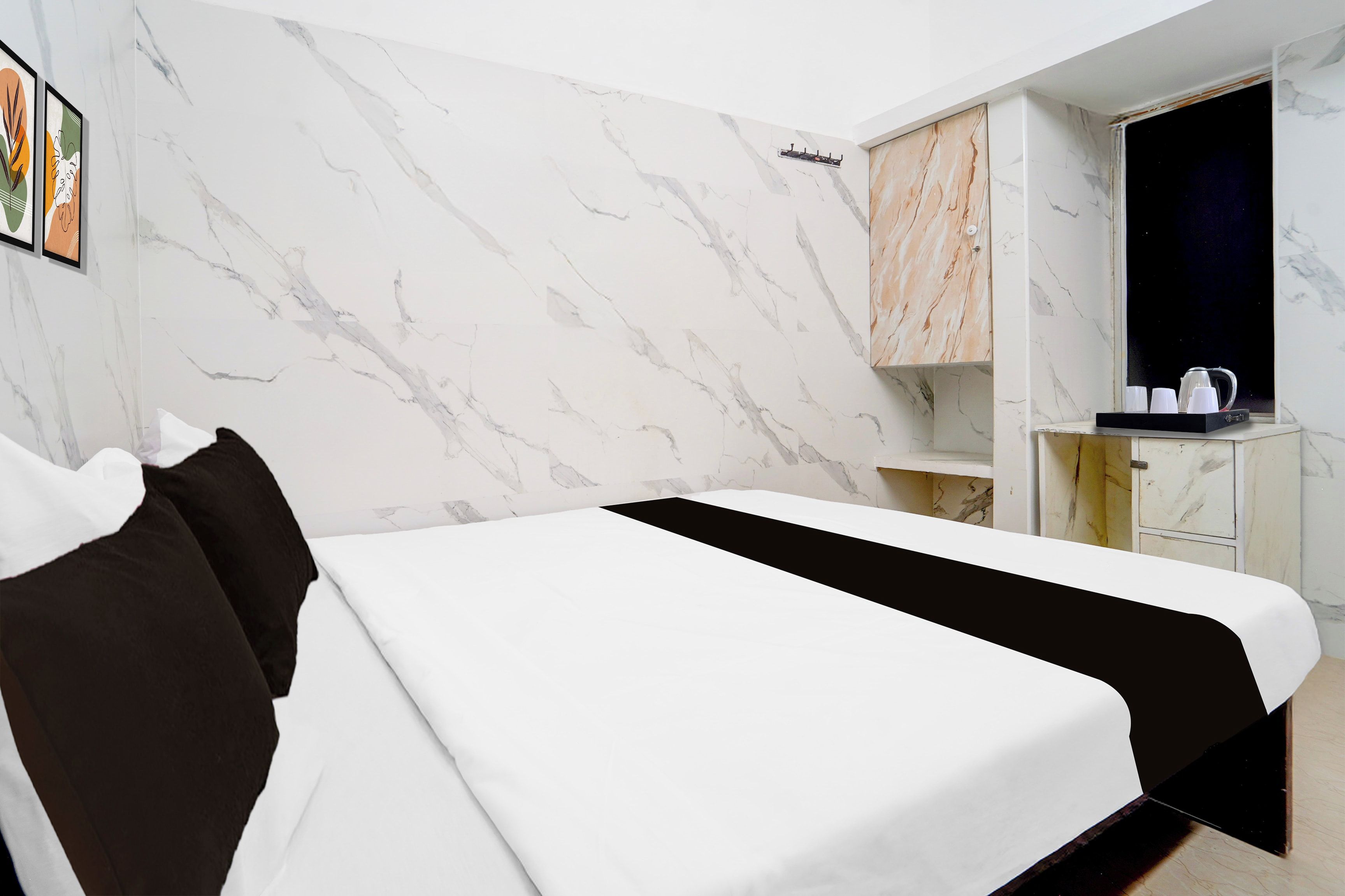 Habitación de hotel con cama, armario y pequeña cocina.