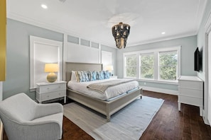 A bedroom with a bed, bedside tables, a chair, a chandelier, and a window. - Sea Rest | Private Pool | Deeded Beach Access | 3 King Suites (Watersound Beach)