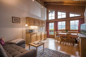 A cozy living room with a sofa, a coffee table, and a dining area with a table and chairs.
