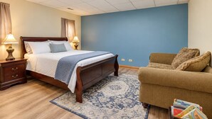 Un dormitorio con cama, mesitas de noche, un sofá y una alfombra.