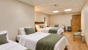 Habitación de hotel con dos camas, una mesita, un radiador y una puerta.