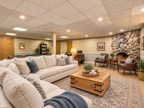A cozy living room with a sectional sofa, a wooden coffee table, and a fireplace. - Spacious Creekside Suite Near Chicago (barrington hill)