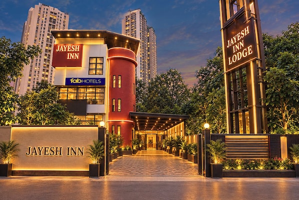 A hotel entrance with a prominent sign for 'Jayesh Inn' and 'Fab Hotels' branding.