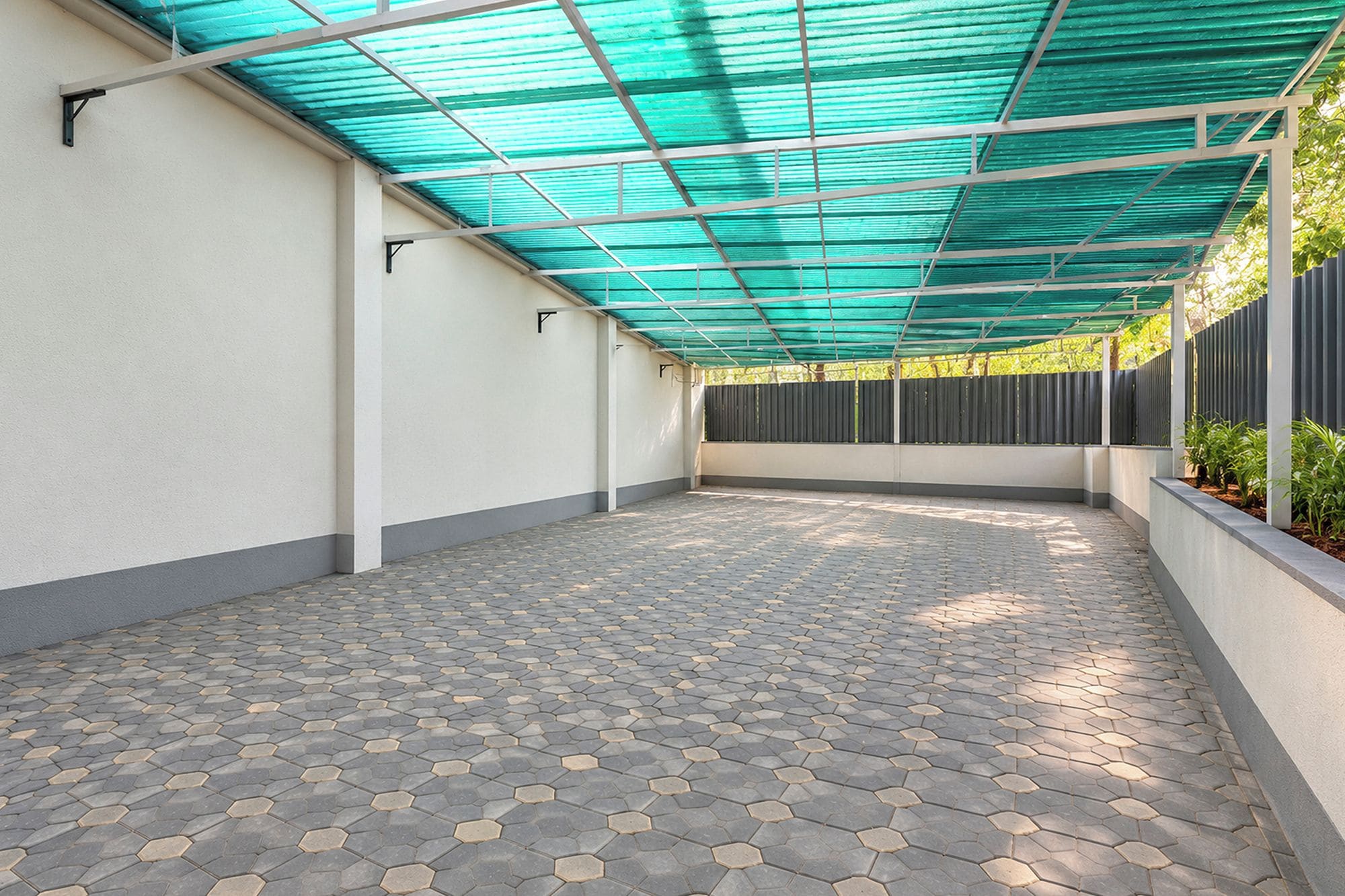 A covered patio area with a patterned floor and a green overhead structure.