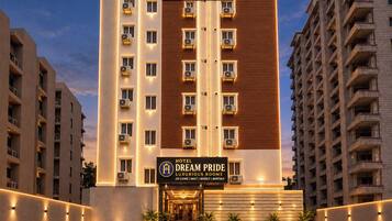 Un edificio de hotel de varios pisos con un cartel que indica 'TabHotels' y 'Hotel Dream Pride Habitaciones Lujosas', mostrando una variedad de tipos de habitaciones y servicios.