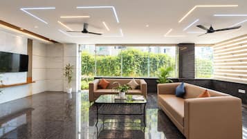Una sala de estar moderna con un sofá, una mesa de centro y ventiladores de techo.
