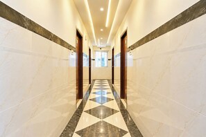 A hotel corridor with marble walls and a geometric patterned floor. - Fabhotel Dream Pride (Hyderabad)