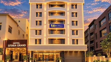 A multi-story hotel with a modern facade, a visible sign for 'fabHOTELS', and a gated entrance.