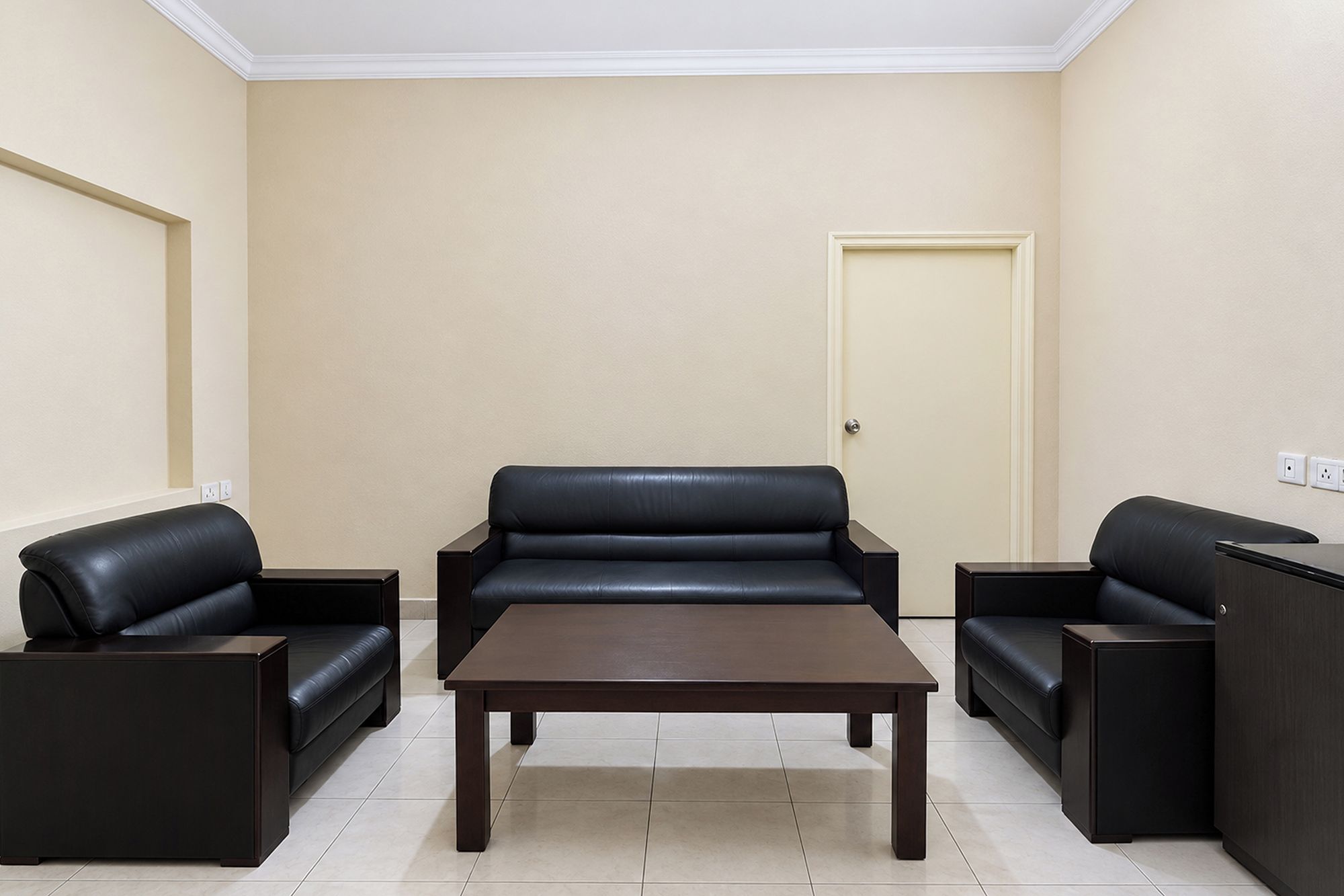 Una sala de estar con un sofá, una mesa de centro y dos mesitas auxiliares.