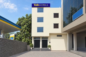 A modern building with a 'fabHOTELS' sign, a flat facade, and a gated entrance. - FabHotel Swastik Anand Vihar (New Delhi)