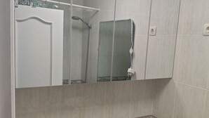 Ein Badezimmer mit Toilette, Dusche und Spiegel.