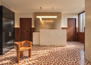 A modern kitchen with a central island, wooden cabinets, and a patterned floor. - The Couper Torretta (Roma)
