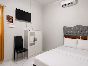 A hotel room with a bed, a wardrobe, a television, and a chair. - Hotel O near Pantai Manggar (Samboja Kuala)