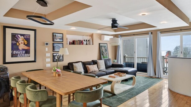 A spacious living area with a wooden dining table, green upholstered chairs, a black leather sofa, and a large window offering a view of the outdoors. - 2-Level Cabin @ Scribners | Huge Spa & 3 Balconies (Tannersville)