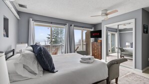 A hotel room with a bed, a TV, a balcony, and a view of the outdoors. - 2-Level Cabin @ Scribners | Huge Spa & 3 Balconies (Tannersville)