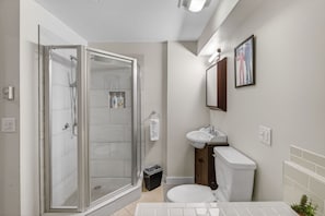 A modern bathroom with a glass-enclosed shower, a toilet, and a sink. - Scribners Retreat | Sleeps 6 | Huge Patio/Jacuzzi (Tannersville)