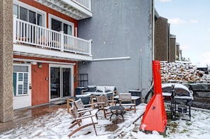 A two-story building with a balcony, outdoor seating area with chairs and tables, and a red fire extinguisher. - Scribners Retreat | Sleeps 6 | Huge Patio/Jacuzzi (Tannersville)