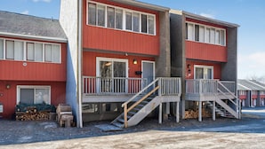 En bygning med flere etager, rød facade, altaner og en trappe op til de øvre etager.