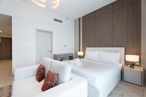 A hotel room with a bed, a sofa, a desk, and a nightstand. - Vanilla Homes Modern Studio Yas Island (Abu Dhabi)