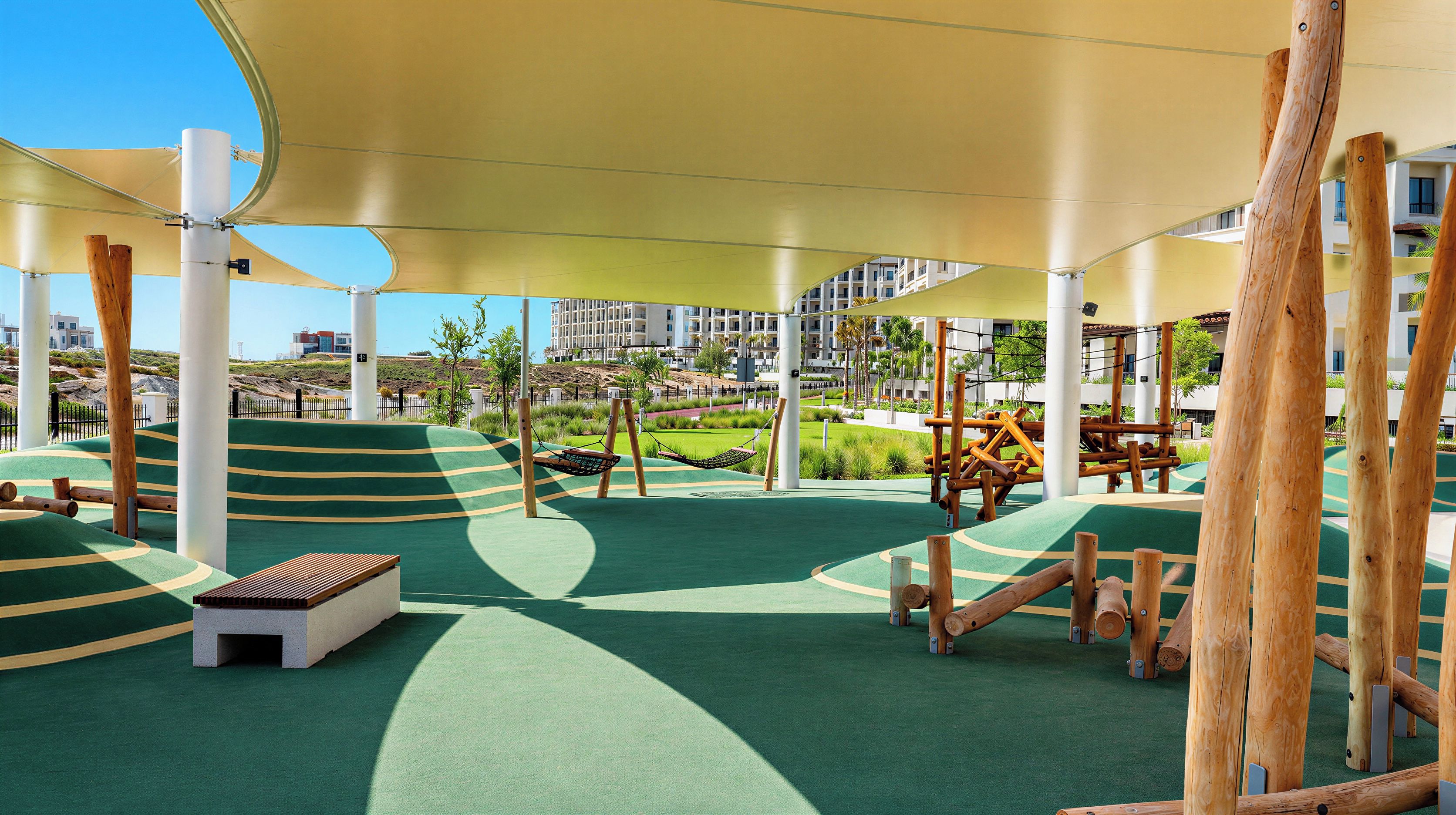 A playground with swings, a slide, and a climbing structure.