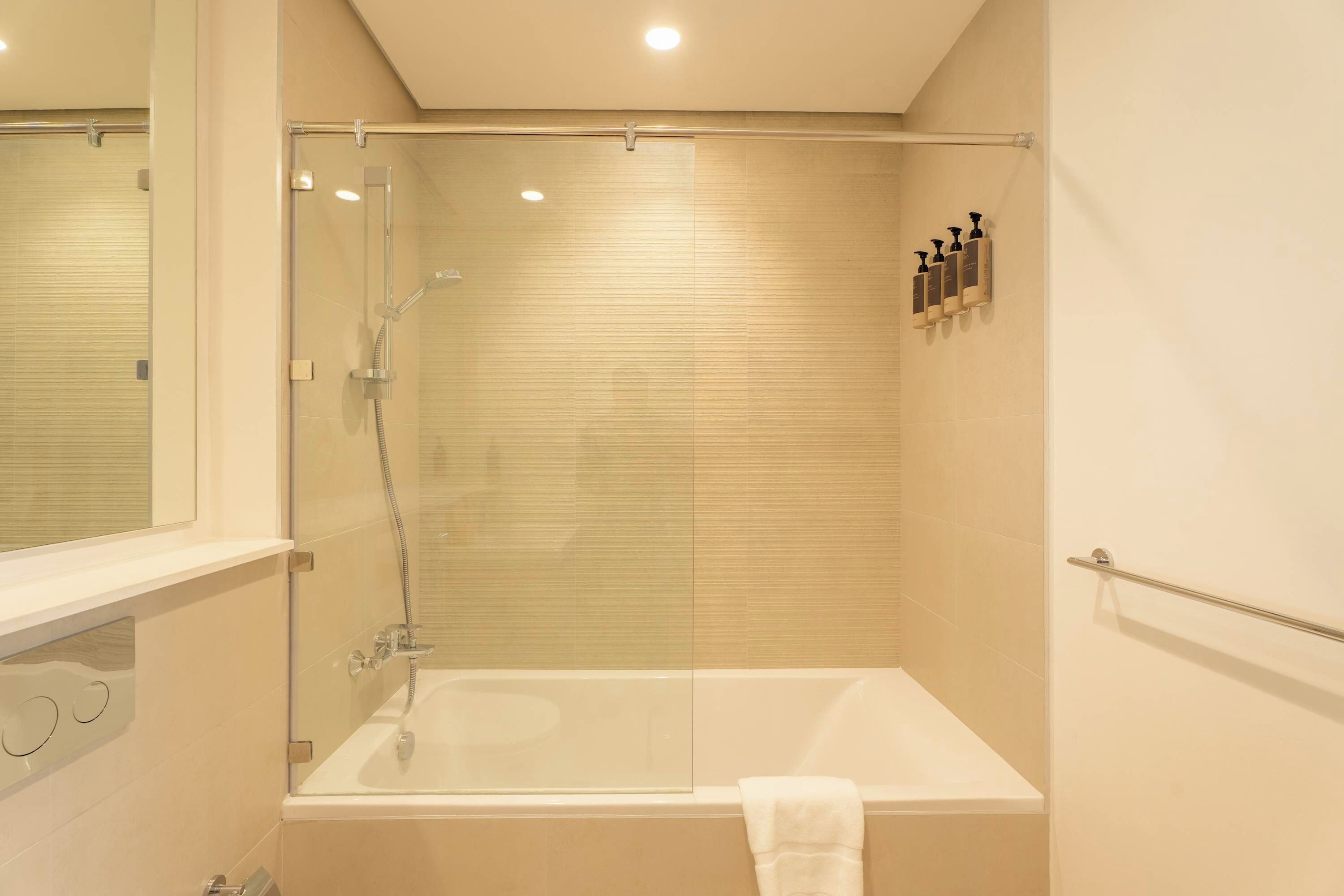 A modern bathroom with a glass-enclosed shower, a bathtub, and a towel rack.