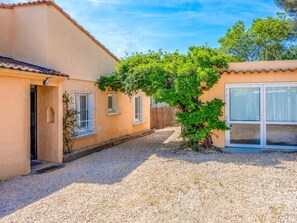 A residential property with a gravel driveway, a tree, and a building with a tiled roof. - Villa in Les Issambres With Swimming Pool (Roquebrune-sur-Argens)