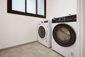 A laundry room with two front-loading washing machines and a dryer. - Spacious 4BR Luxury l Balcony & Mamad (Petah Tikva)