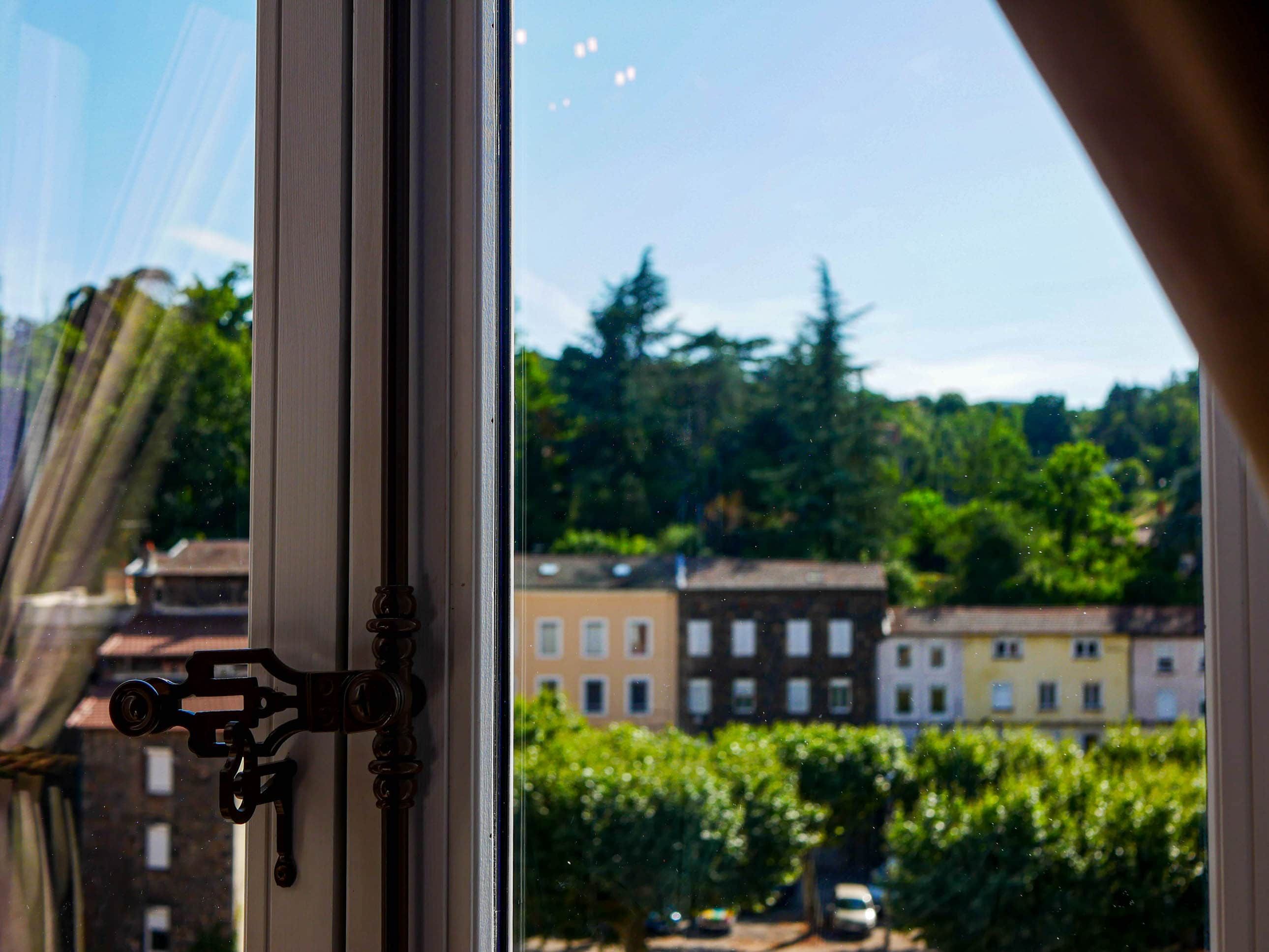 A window with a view of buildings and trees.