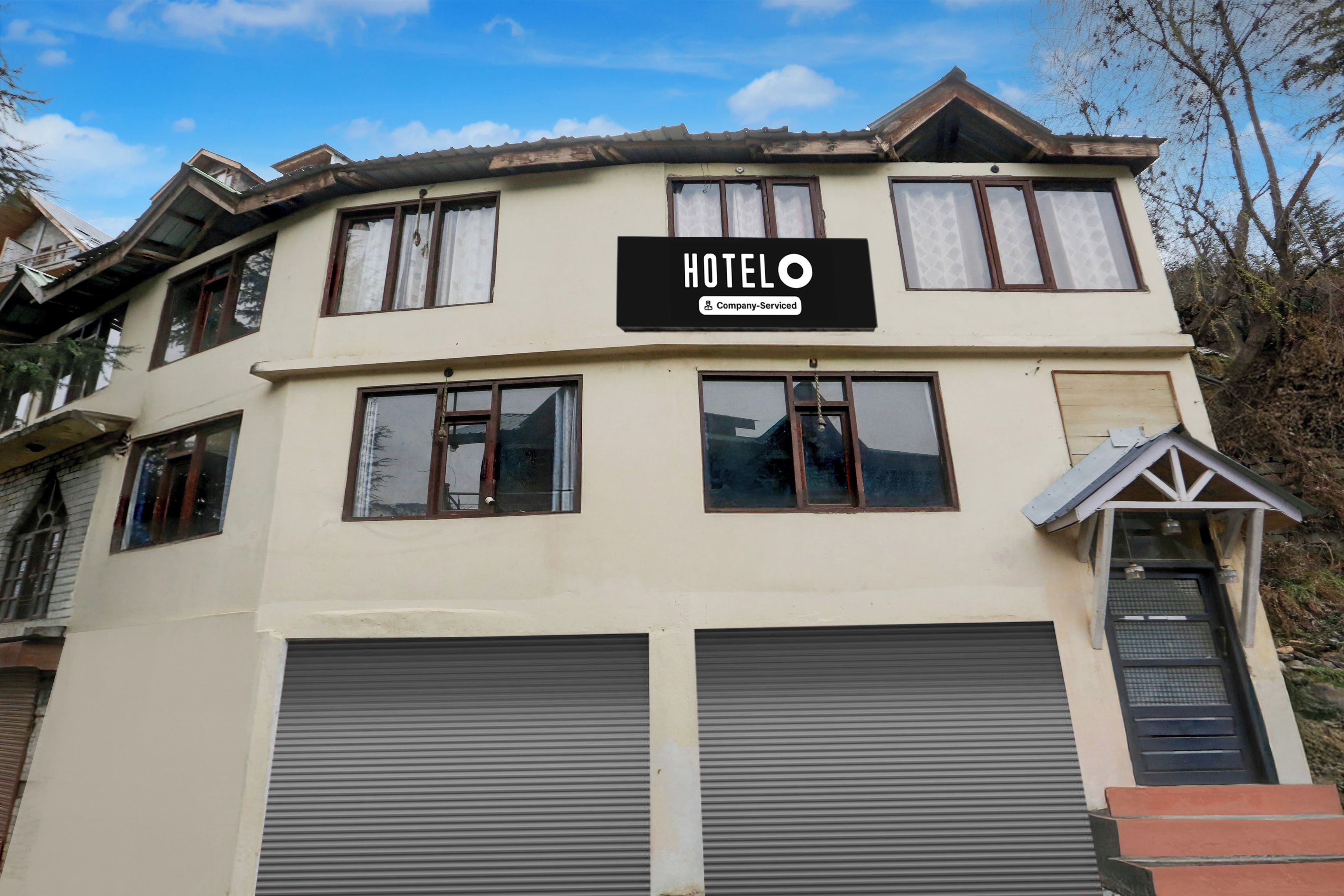 Un edificio de dos pisos con un letrero que dice 'HOTEL Company Serviced'.