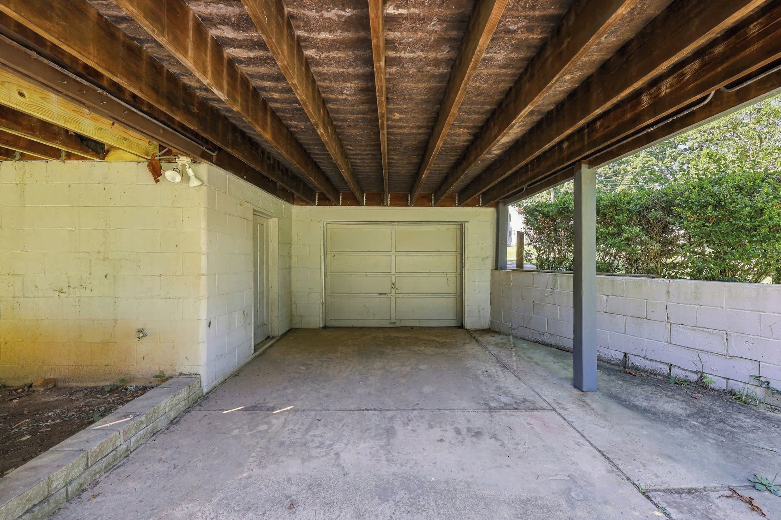 A garage with a concrete floor and a white door.