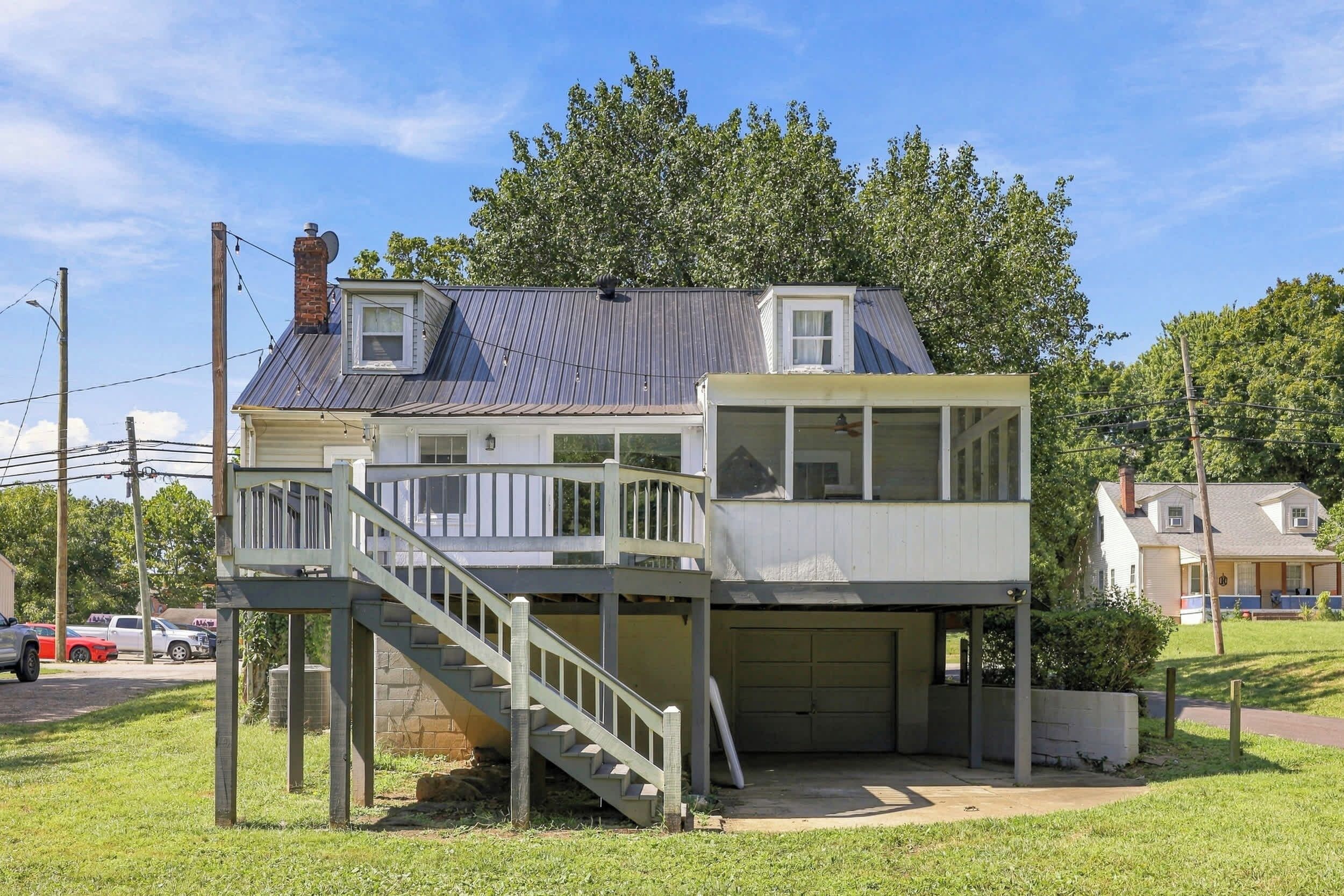 Ein zweistöckiges Haus mit Balkon, Garage und einer Treppe, die zum oberen Stock führt.