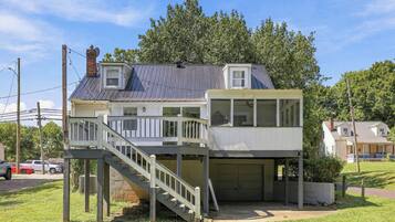 Ein zweistöckiges Haus mit Balkon, Garage und einer Treppe, die zum oberen Stock führt.