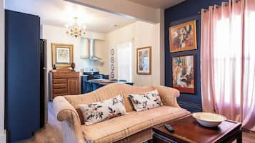 A living room with a sofa, coffee table, and artwork on the walls.