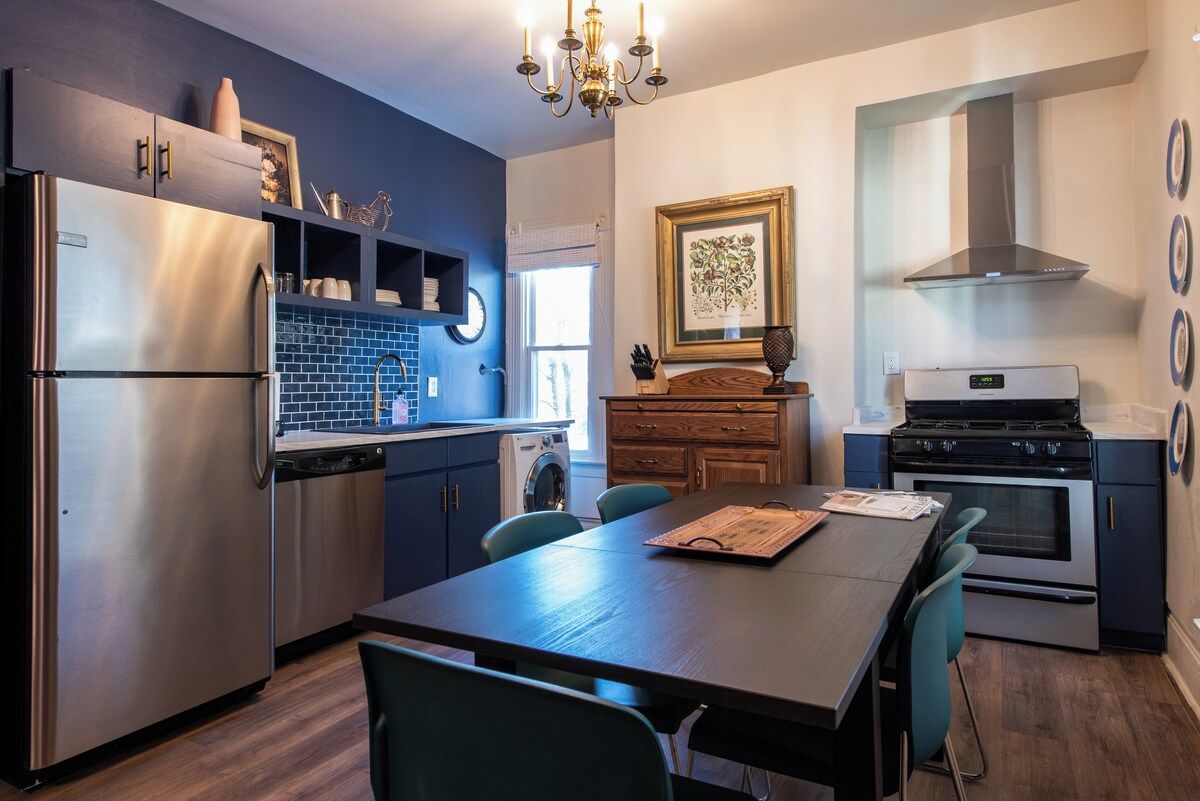 A modern kitchen with a stainless steel refrigerator, a built-in oven, and a stove.