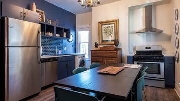 A modern kitchen with a stainless steel refrigerator, a built-in oven, and a stove.