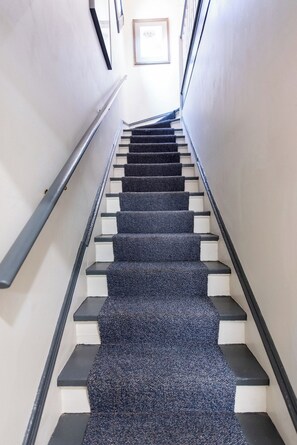 Eine Treppe mit einem Teppichbelag und einem Geländer auf der linken Seite.