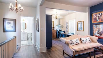A spacious living area with a sofa, a dining table, and a kitchen in the background.