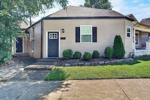 A single-story house with a front door, two windows, and a mailbox.