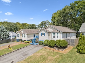 A row of single-story houses with a front yard, a driveway, and a wooden fence.