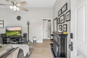 A modern living room with a television, a fireplace, and a ceiling fan. - Iconic Music City retreat w/ backyard and hot tub! (Nashville)