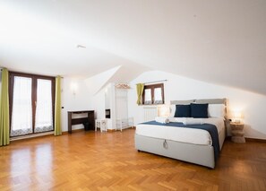 Ein Schlafzimmer mit einem großen Bett, einem Schreibtisch und einem Kleiderschrank.