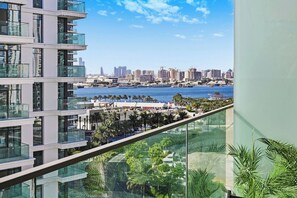 A high-rise building with multiple balconies overlooking a marina and city skyline. - Premium 1BR - Creek Harbour - Pool, Sea View (Dubai)