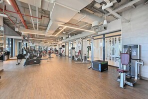 A gym with cardio machines, weight stations, and a mirrored wall. - Premium 1BR - Creek Harbour - Pool, Sea View (Dubai)