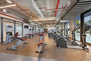 A gym with cardio machines, weight stations, and benches. - Premium 1BR - Creek Harbour - Pool, Sea View (Dubai)