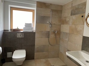 A bathroom with a toilet, a shower, and a sink. - Ground Floor Alpenchic Apartment with Garden and Terrace (Ottobeuren)