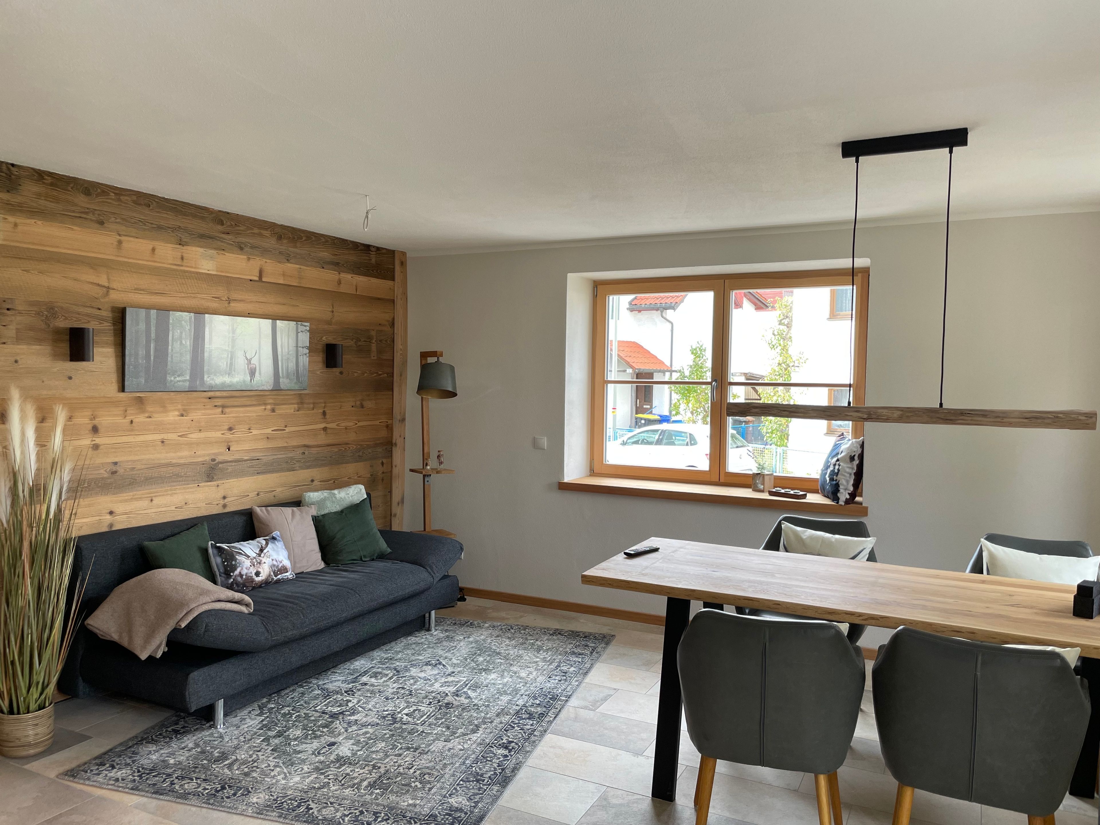 Een moderne woonkamer met een bank, een eettafel en stoelen.